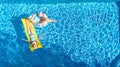 Children in swimming pool aerial drone view fom above, happy kids swim on inflatable ring donut and mattress, girls have fun Royalty Free Stock Photo