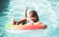 Children in swimming pool. Summer outdoor. Happy kid playing with colorful swim ring in swimming pool. Child water toys Royalty Free Stock Photo