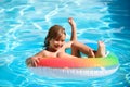 Children in swimming pool. Summer outdoor. Happy kid playing with colorful swim ring in swimming pool. Child water toys