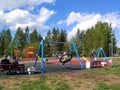 Children swing on a swing in the playground.