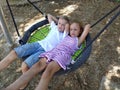 Children swing on a spider-web swing. Boy and girl, brother and sister in the summer on the playground. Swinging the swing. Royalty Free Stock Photo