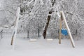 Children swings playground covered with snow in winter time Royalty Free Stock Photo