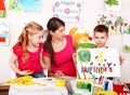 Children with teacher draw paints in classroom. Royalty Free Stock Photo