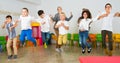 Children with teacher jumping together in schoolroom