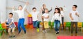 Children with teacher jumping together in schoolroom