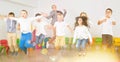 Children with teacher jumping together in schoolroom