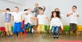 Children with teacher jumping together in schoolroom