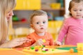 Children play with plasticine in kindergarten