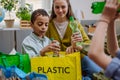 Children with teacher separating rubish in to three bins. Royalty Free Stock Photo