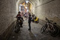 Children and teenagers, boys, standing on bicycles and motorcycles in an alley of Vakil Bazar, the main covered market of the city
