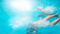 Children teenagers girls have fun swimming and diving in the outdoor pool, feet up over the water, splashing, sunlight, glare, Royalty Free Stock Photo