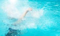 Children teenagers girls have fun swimming and diving in the outdoor pool, feet up over the water, splashing, sunlight, glare, Royalty Free Stock Photo