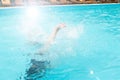 Children teenagers girls have fun swimming and diving in the outdoor pool, feet up over the water, splashing, sunlight, glare, Royalty Free Stock Photo