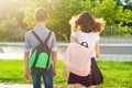 Children teenagers go to school, back view. Outdoors, teens with backpacks. Royalty Free Stock Photo