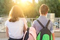 Children teenagers go to school, back view. Outdoors, teens with backpacks Royalty Free Stock Photo