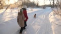 Children teens travel in winter in the park with a dog. two girls and dog and dog walk along path in winter park Royalty Free Stock Photo