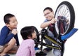 Children and their dad repair a bicycle Royalty Free Stock Photo