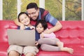 Children and their dad using laptop at home Royalty Free Stock Photo