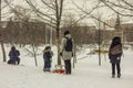 Children and their parents sledding in the winter in the snow