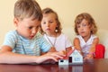 Children three together looking at model of house Royalty Free Stock Photo