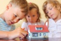 Children three together looking at model of house Royalty Free Stock Photo