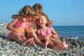 Children three together sitting on stony beach Royalty Free Stock Photo