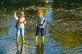 Children throw stones at the Stony river. Beautiful children throws a rock at the river. Skipping Rocks. Royalty Free Stock Photo