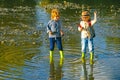 Children throw stones at the Stony river. Beautiful children throws a rock at the river. Skipping Rocks. Royalty Free Stock Photo