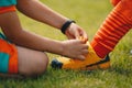 Children tie shoelaces at grass sports field Royalty Free Stock Photo