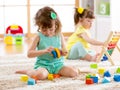 Children toddler and preschooler girls play logical toy learning shapes, arithmetic and colors at home or nursery Royalty Free Stock Photo