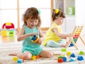 Children toddler and preschooler girls play logical toy learning shapes, arithmetic and colors at home or nursery