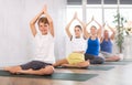 Children together with parents in yoga pose agni stambhasana