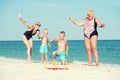 Children together with their mother and grandmother playing a game throwing rings on the beach Royalty Free Stock Photo