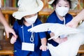 Children are touching the feathers on the white duck with their hands. Sensory learning with farm animals.