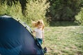 Children tourism. Happy kid girl in a campaign in a tent. Family summer vacation in nature