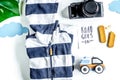 Children tourism outfit with clothes and camera on white background flat lay