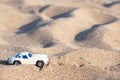 Children toy white car in the child's hand. Side view. Insurance, bank loan, travel, travel concept. Beach in the Royalty Free Stock Photo