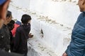 Children trying to put their hands in a hole with closed eyes in Pashupatinath temple, Kathmandu, Nepal