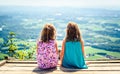 Children - twin girls sitting on paragliding ramp after hiking.