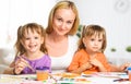 children twin sisters draw paints with her mother in kindergarten Royalty Free Stock Photo