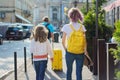 Children two girls daughters and father, tourists walking with backpacks and suitcase