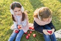 Children two girls eating red apples in yellow autumn park Royalty Free Stock Photo