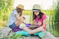 Children two girls resting playing reading their notebook in nature Royalty Free Stock Photo