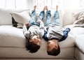 Children upside down, playing and happy at family home for fun with sibling, brothers on sofa and relax in living room