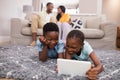 Children using digital tablet while parents siting on sofa at home Royalty Free Stock Photo