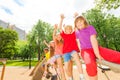 Children waive hands sitting in row on round bar Royalty Free Stock Photo