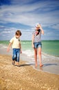 Children walk along the coast vertical