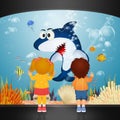 Children watch the shark in the aquarium