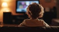Child watching TV on the sofa, rear view Royalty Free Stock Photo