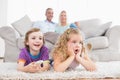 Children watching TV while parents sitting on sofa Royalty Free Stock Photo